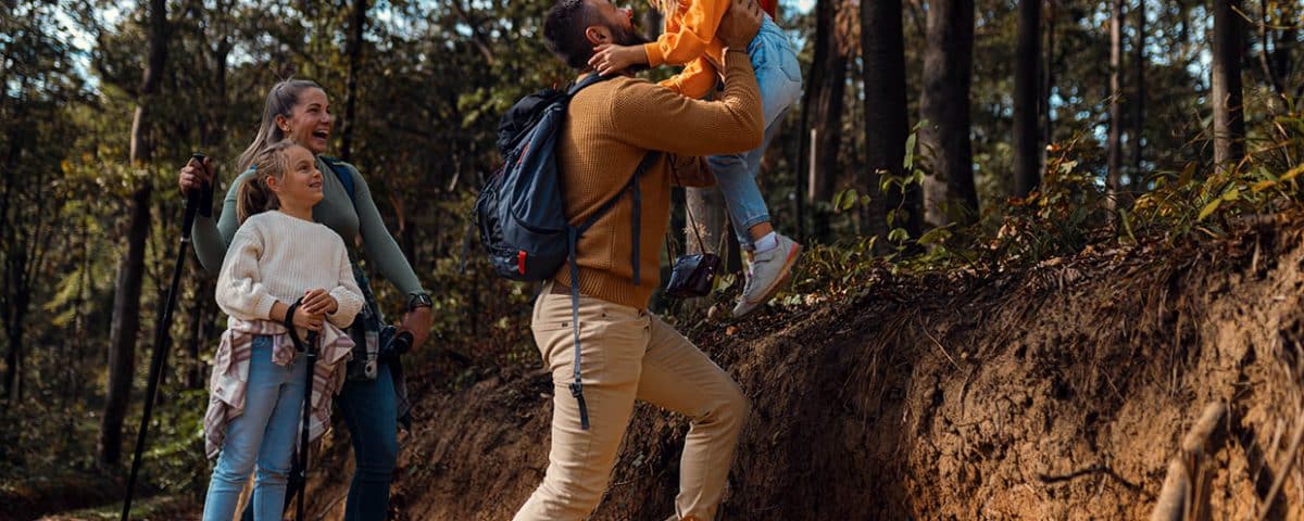 Family hiking a wooded trail during a spring adventure near Grand Rapids, Michigan