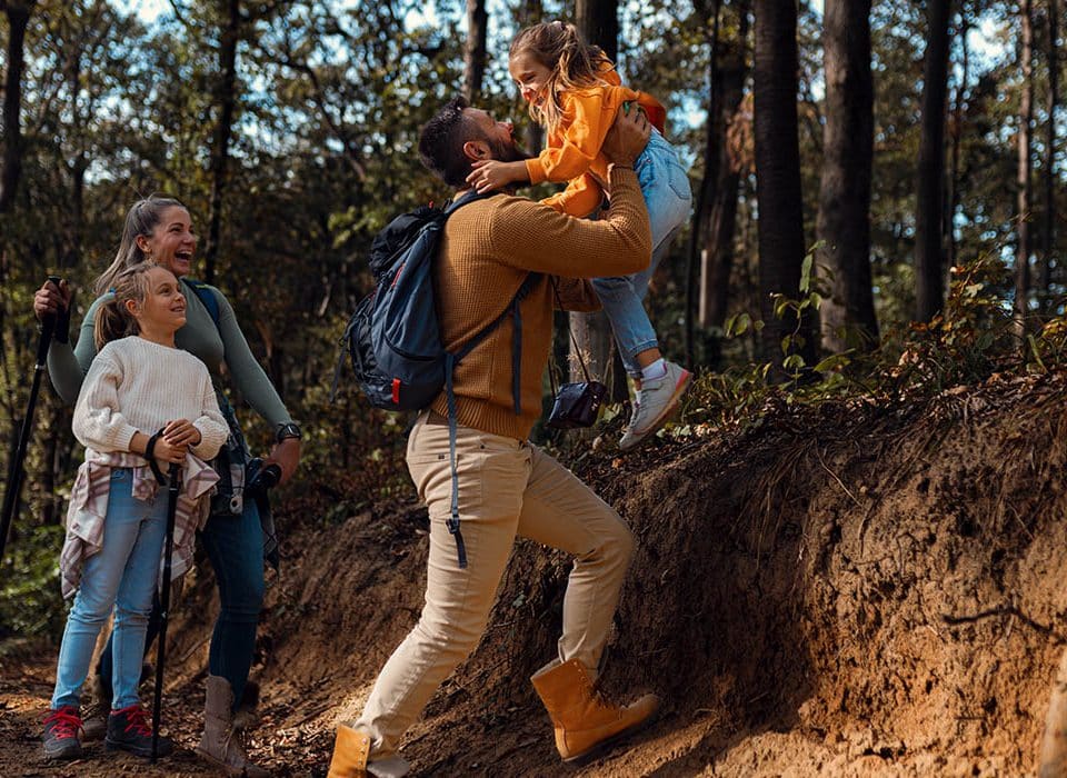 Family hiking a wooded trail during a spring adventure near Grand Rapids, Michigan